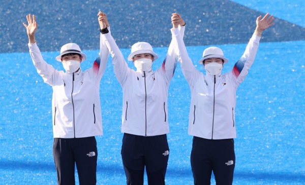 25일 일본 유메노시마 공원 양궁장에서 열린 도쿄올림픽 여자 양궁 단체 결승전에서 금메달을 획득한 여자 양궁국가대표 안산(왼쪽부터), 장민희, 강채영이 시상대에 오르며 환호하고 있다. [사진=도쿄올림픽 기자단]